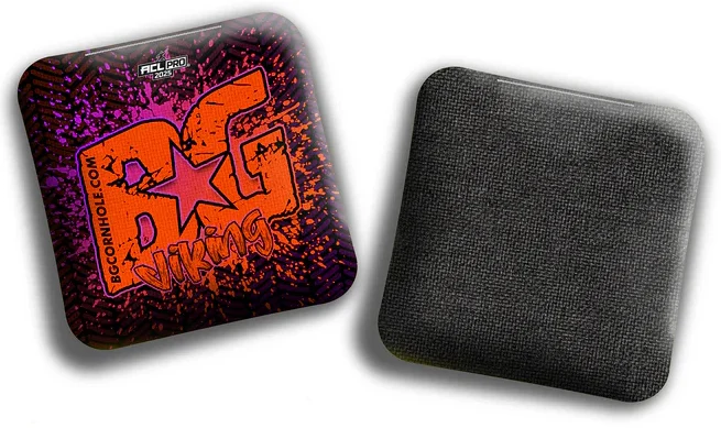 A BG Viking cornhole bag with a vibrant orange and purple splatter design. The bold "BG Viking" logo is prominently displayed in the center with a star accent, while the ACL Pro 2025 logo sits at the top. The bag's backside features a black, textured fabric, indicating its durable, high-quality build designed for pro-level play.