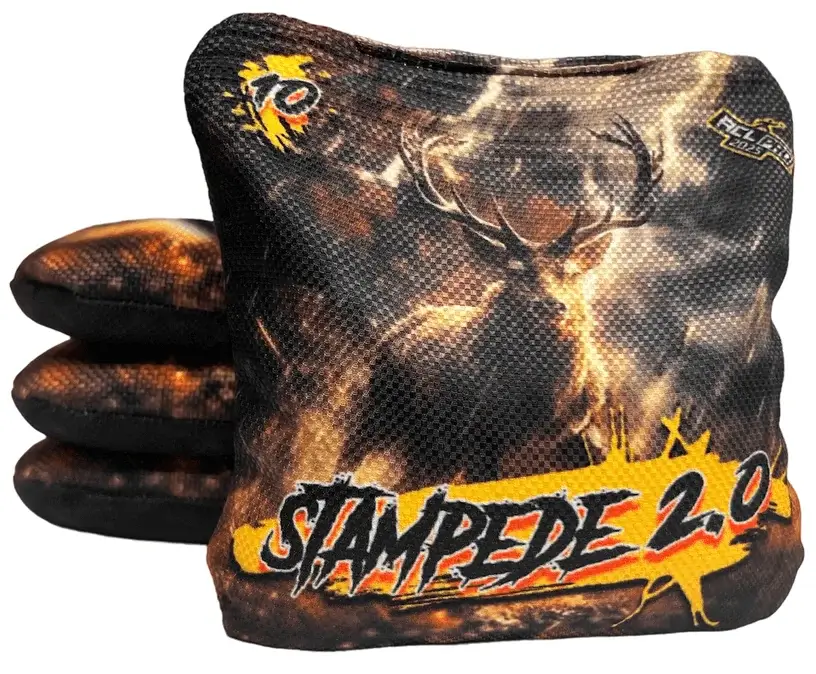 A set of Titan Cornhole bags from the Stampede 2.0 series, featuring a bold design with a buck in a dark, fiery orange and black background. The text 'STAMPEDE 2.0' is prominently displayed at the bottom with a speed rating of 10 in the upper left corner, indicating its fast, slick playstyle.