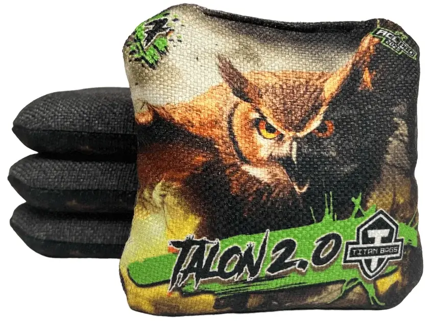 A set of Titan Cornhole bags from the Talon 2.0 series, featuring a striking owl design with earthy tones of brown, black, and green. The text 'TALON 2.0' is boldly displayed along with the Titan Bags logo, and the speed rating of 6 is shown in the upper left corner, indicating its controlled and balanced play style.