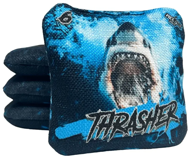 Set of Titan Cornhole bags from the Thrasher series, featuring a blue shark design with a bold oceanic background. The text 'THRASHER' is prominently displayed on the bags along with a speed rating of 6.