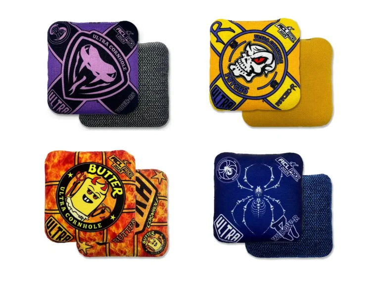 This image showcases four Ultra Cornhole bags with unique designs. The top left bag is the Ultra Viper-RS in purple and black, featuring a bold viper logo with a gray textured back. The top right is a Psycho-R bag in bright yellow, highlighted by a skull logo and a smooth yellow back. At the bottom left, the Ultra Butter bag displays a fiery orange and red design with a playful butter character holding a pitchfork, paired with a matching flame-like pattern on the back. Finally, the bottom right bag is the Ultra Widow-R in navy blue, featuring a skeletal spider graphic and a textured blue back for enhanced grip.