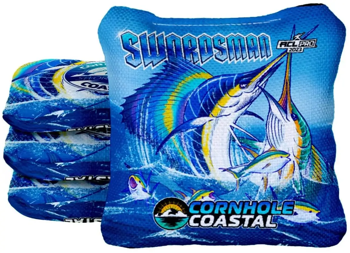 Swordsman Cornhole Coastal Bags: A dynamic blue cornhole bag design with a marlin leaping from the water. The "SWORDSMAN" text and Cornhole Coastal logo are prominently displayed, alongside the ACL Pro 2023 badge.
