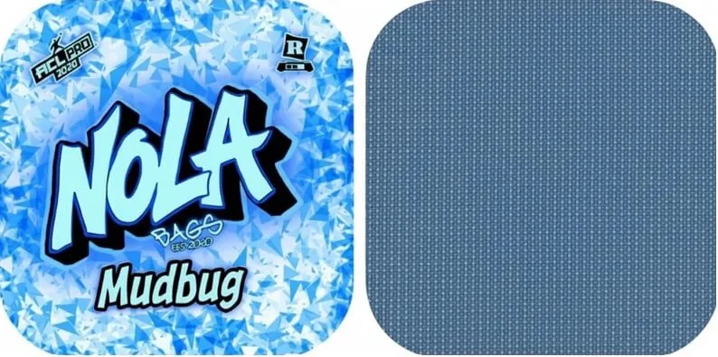 Blue ice-themed logo for Nola Bags Cornhole featuring the bold word “NOLA” in light blue with black outline, the word “Mudbug” below, and ACL Pro 2026 and Rated R icons in the corners.