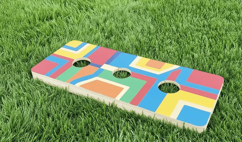 
Model
A vibrant, rectangular washer toss board rests on bright green grass. The board features a colorful geometric pattern with shades of red, blue, yellow, green, and orange. Three circular holes are cut into the board in a straight line.