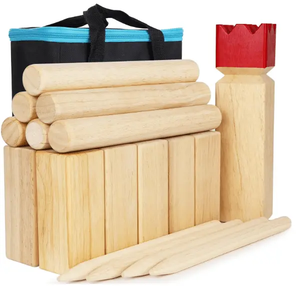 This image shows a wooden Kubb game set. It includes a black and blue carrying bag, one king kubb with a red crown, ten kubbs, and six throwing dowels.